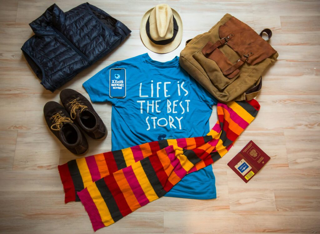 overhead view of a blue tshirt that says "Life is the Best Story". Also a scarf, hat, shoes, backpack and puffer vest. 
nonprofit blogging tips
